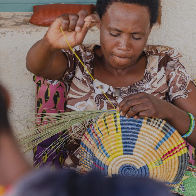 Talking through Art member Clementine weaving a colourful basket. TTA HQ in Kigali.